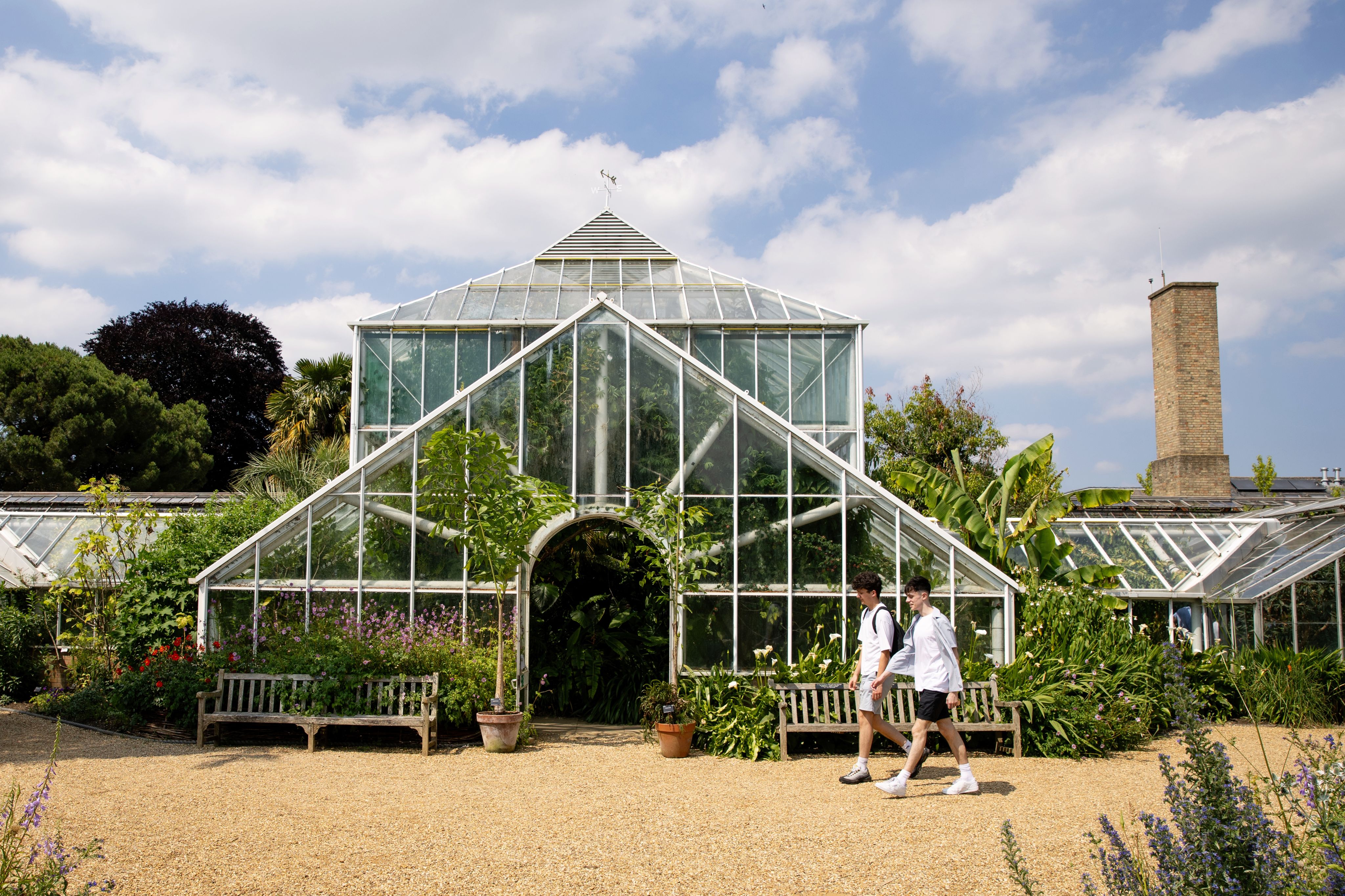 Two students walking past Cambridge University Botanic Garden.