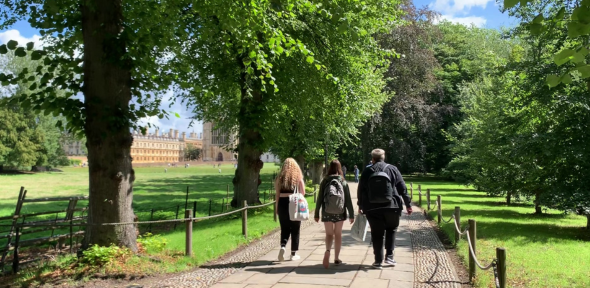 2023 interns Chloe, Farradeh and Jay walking through the Backs towards King's College in Cambridge